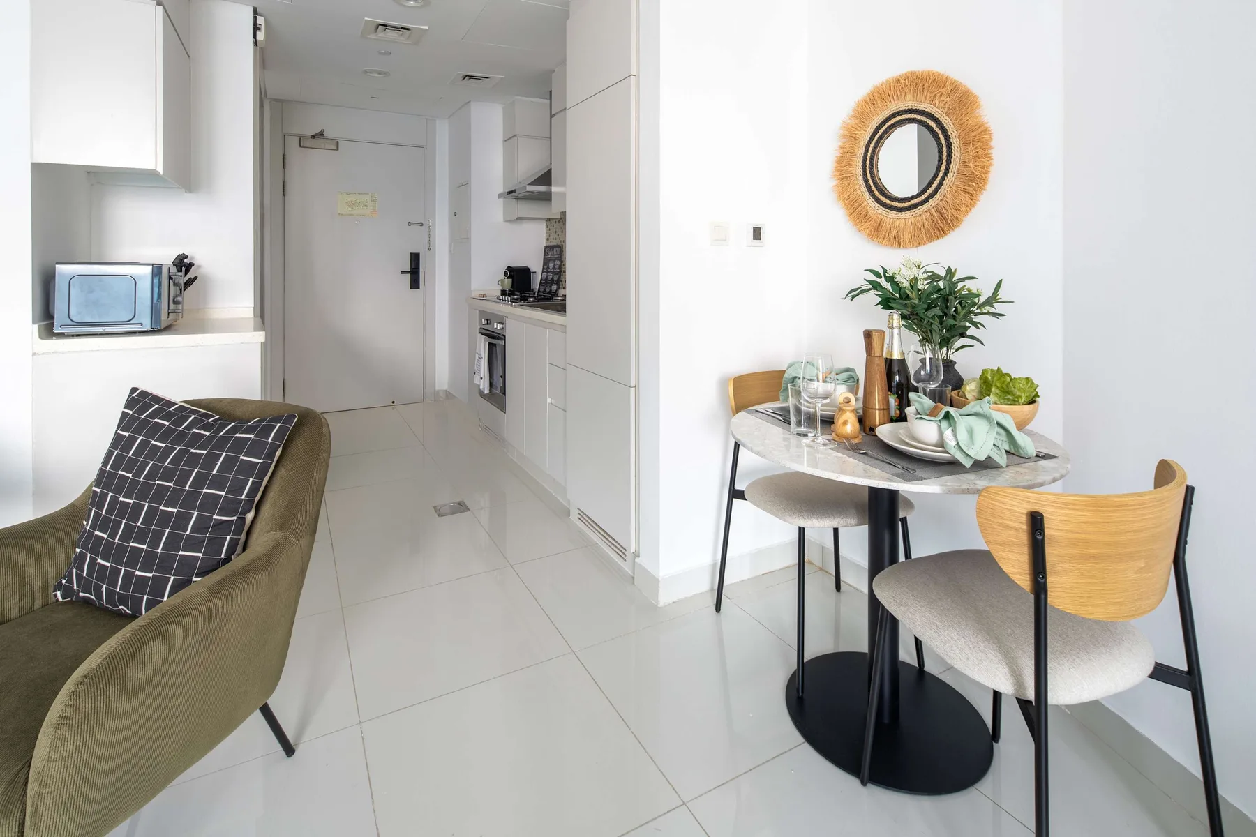 Una cocina y comedor luminosos con una mesa redonda pequeña y asientos.
