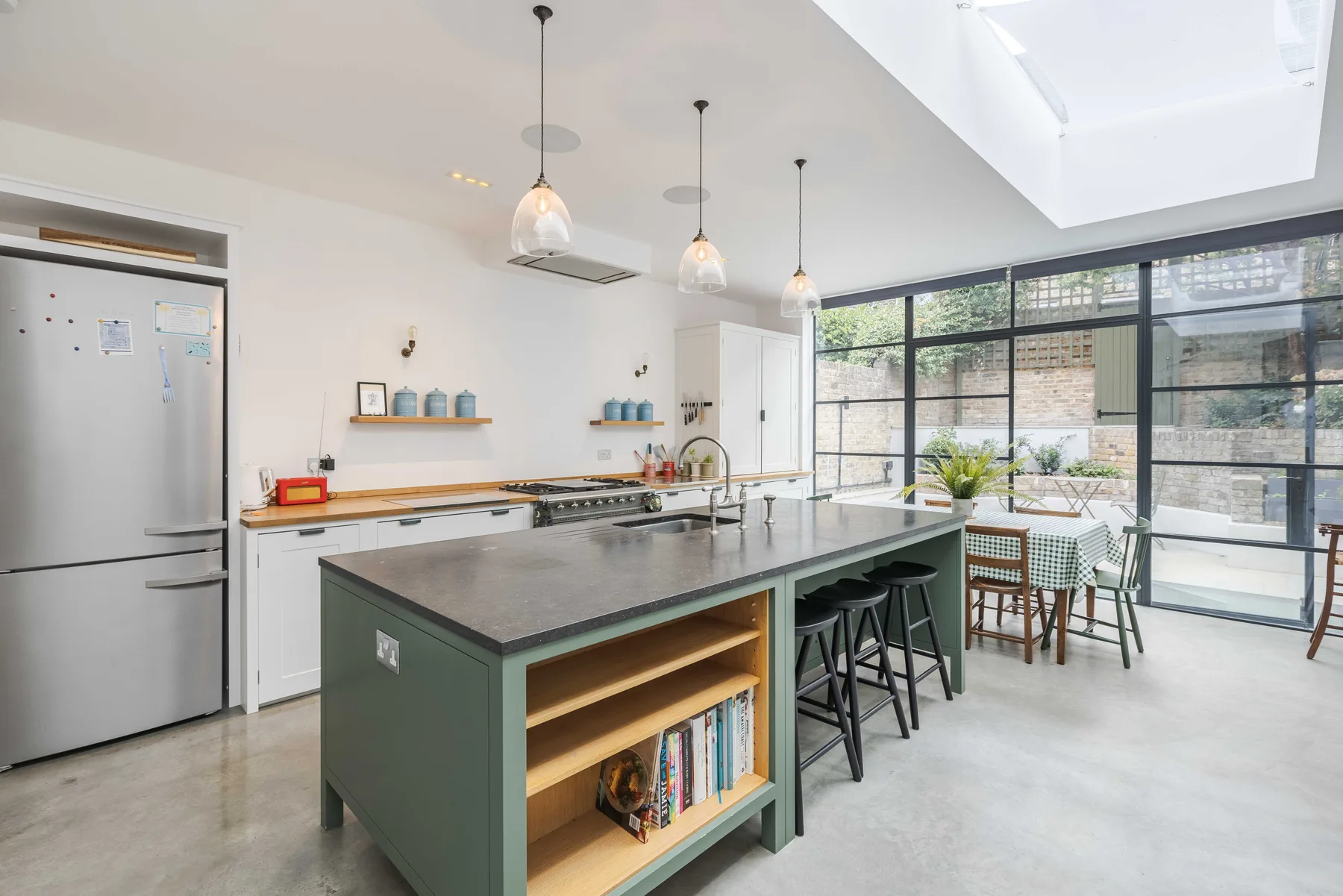 A bright kitchen with a long island, bar seating, and large windows.