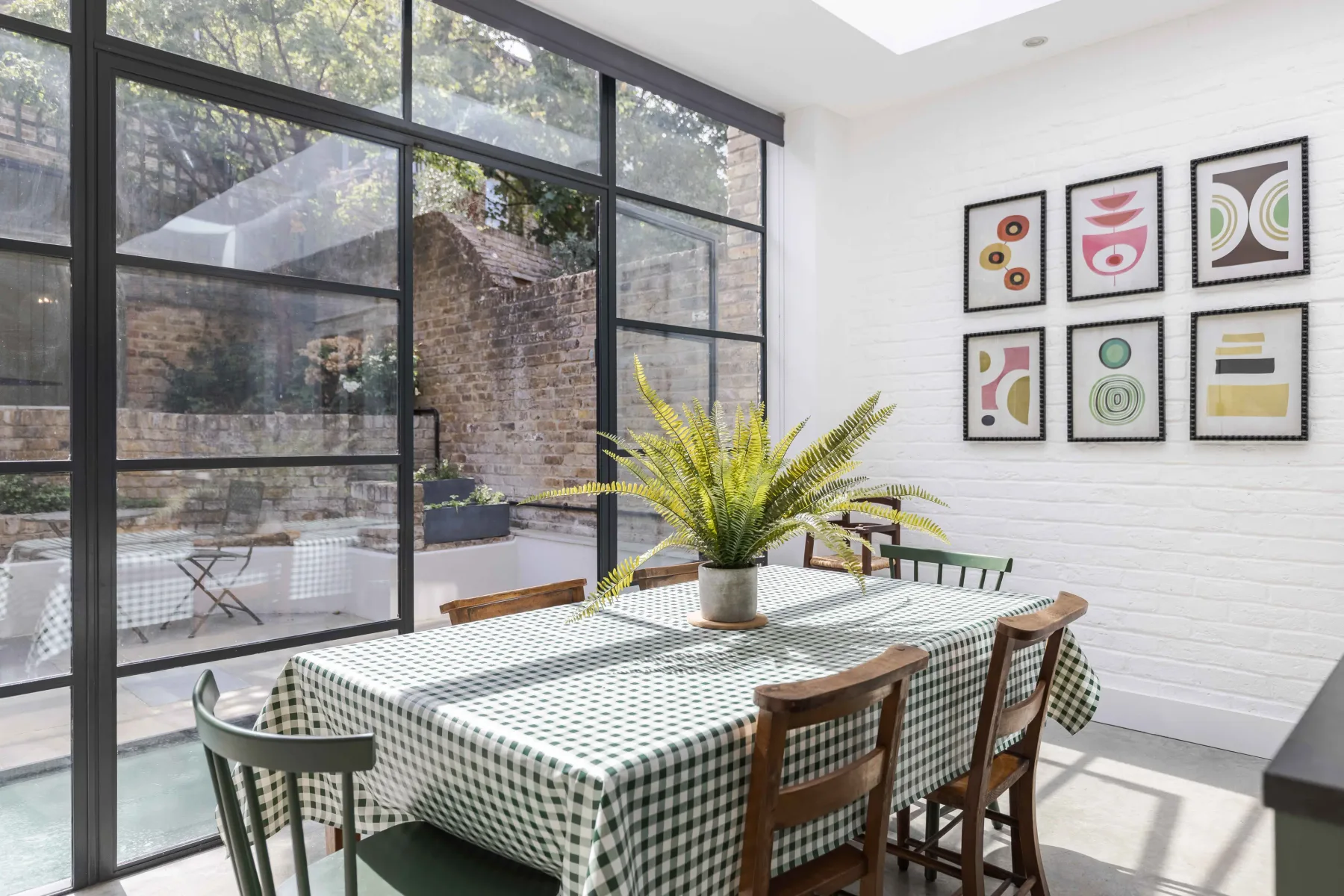 A bright dining area with a checkered tablecloth and large windows.