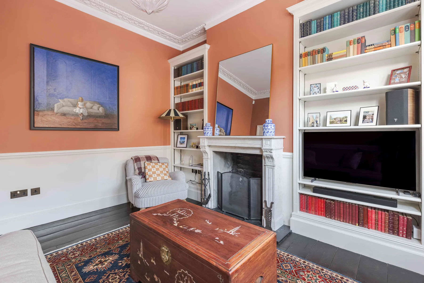 A living room with a fireplace, built-in bookshelves, and a wooden coffee table.