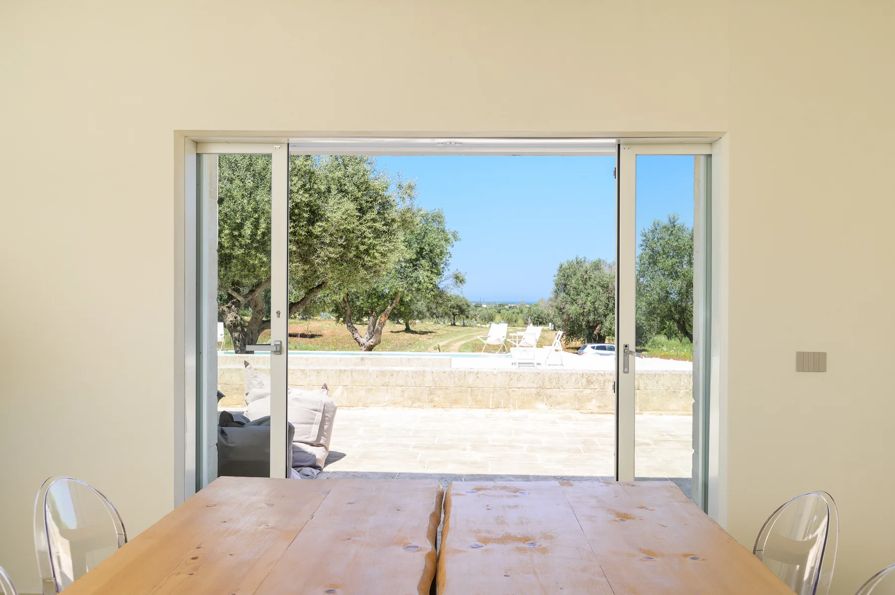 A dining area opens through sliding glass doors to a sunny outdoor terrace.