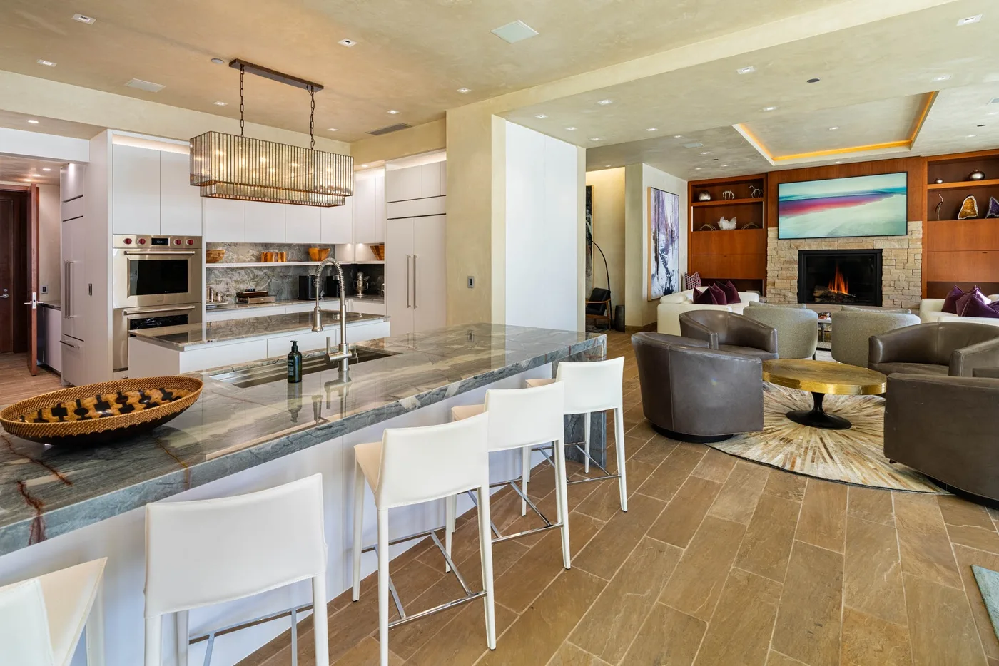 An open-plan living room and kitchen with a dining counter and fireplace.