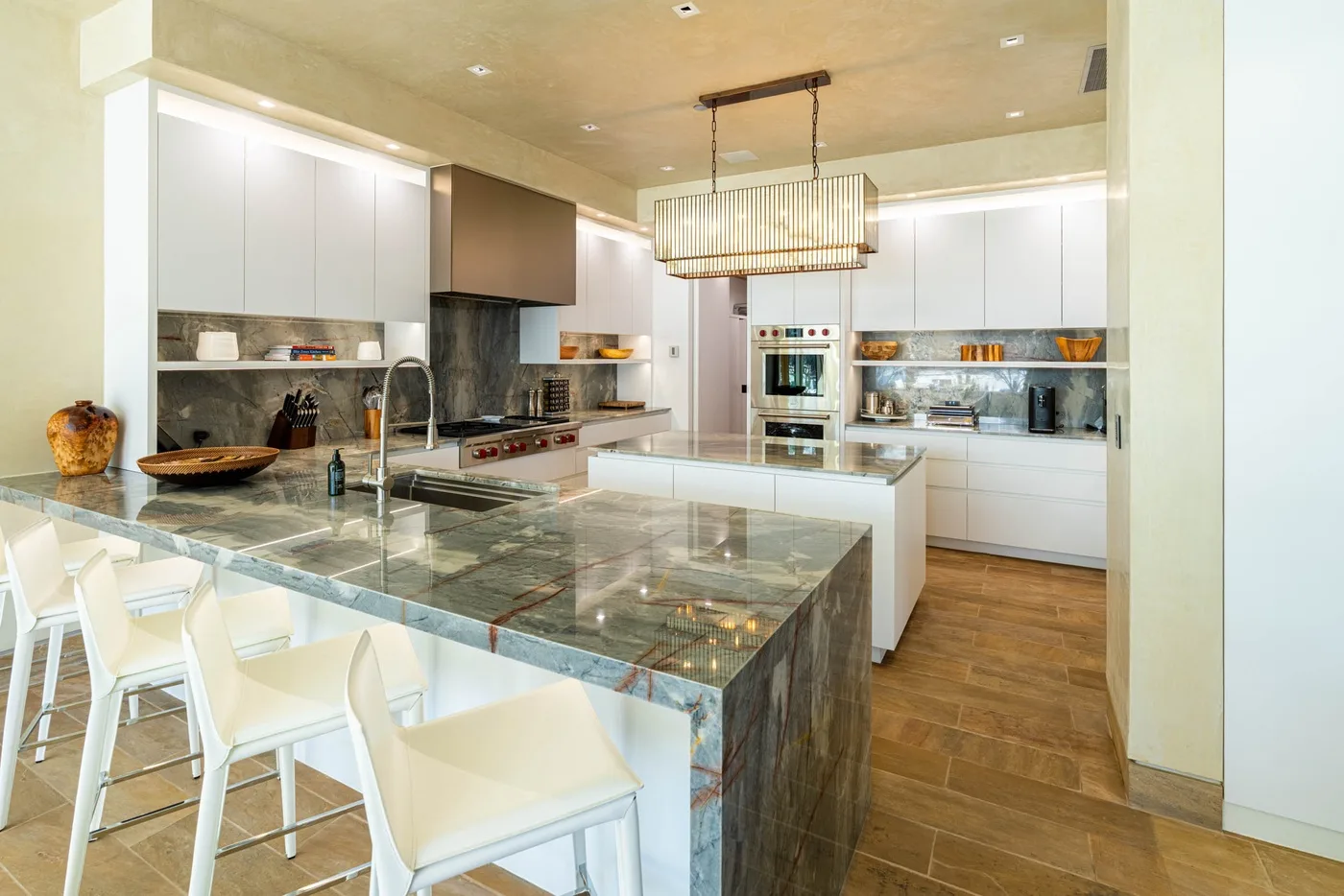 A spacious kitchen with a large island and white cabinetry.