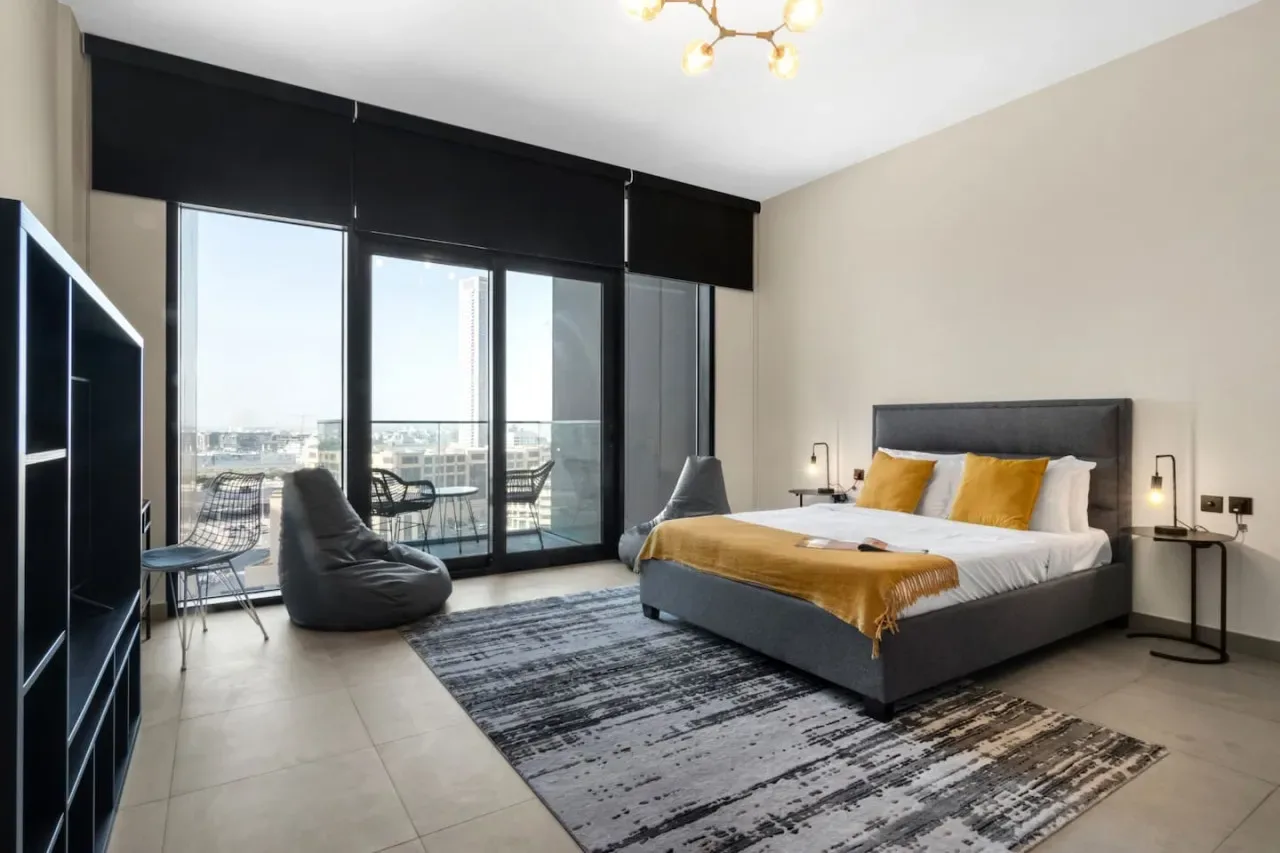 Un dormitorio moderno con una cama grande junto a ventanales de piso a techo.