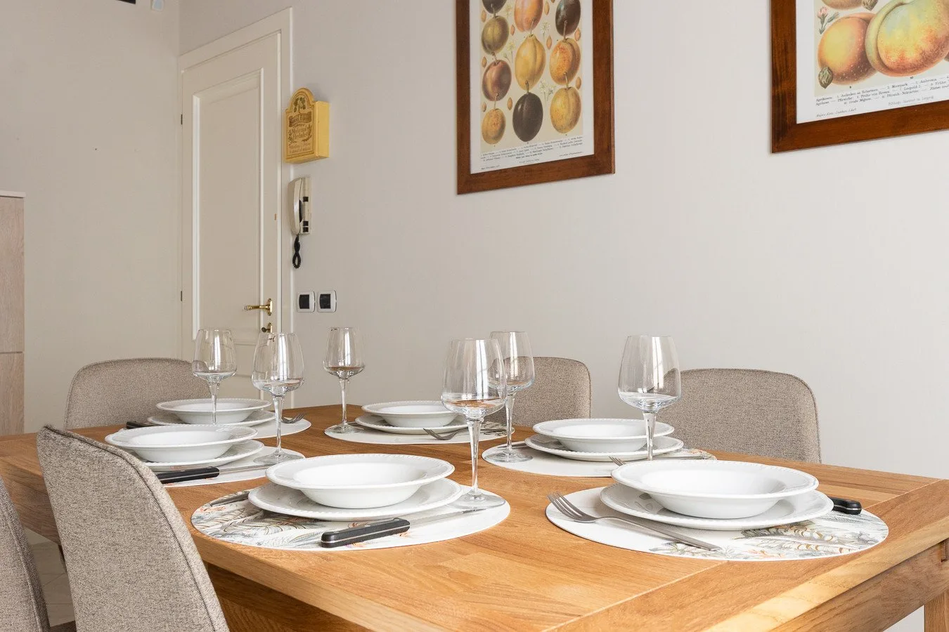 A dining table is set with plates, glasses, and cutlery.