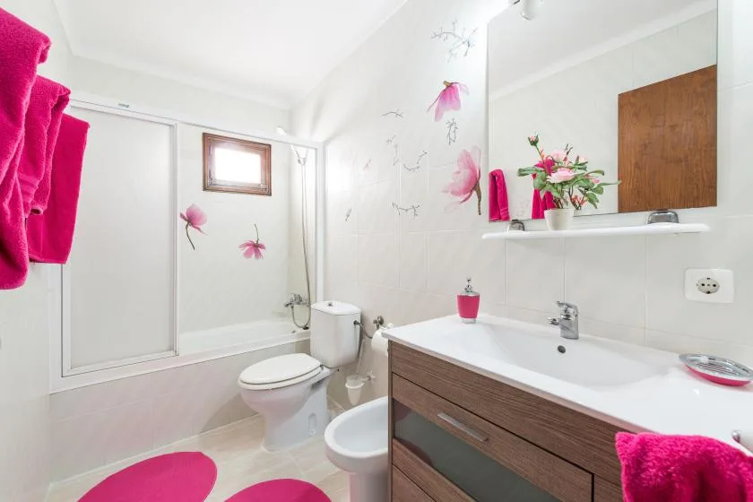 A bright bathroom with a bathtub, vanity, and floral decorations.