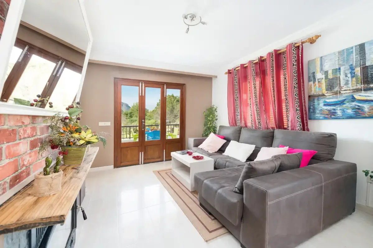 A living room with a gray sectional sofa and colorful curtains.