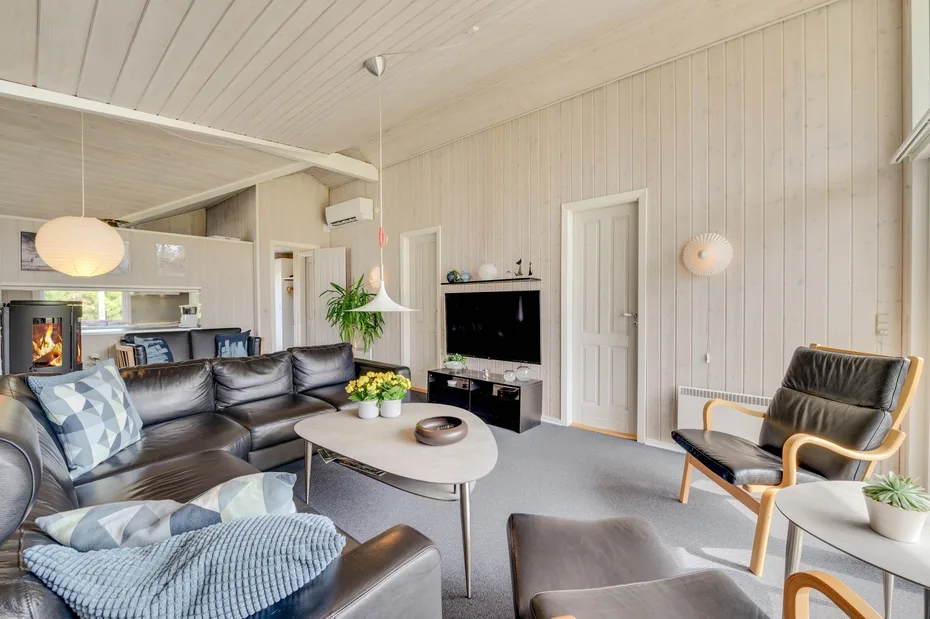 A living room with dark seating, a television, and a low coffee table.