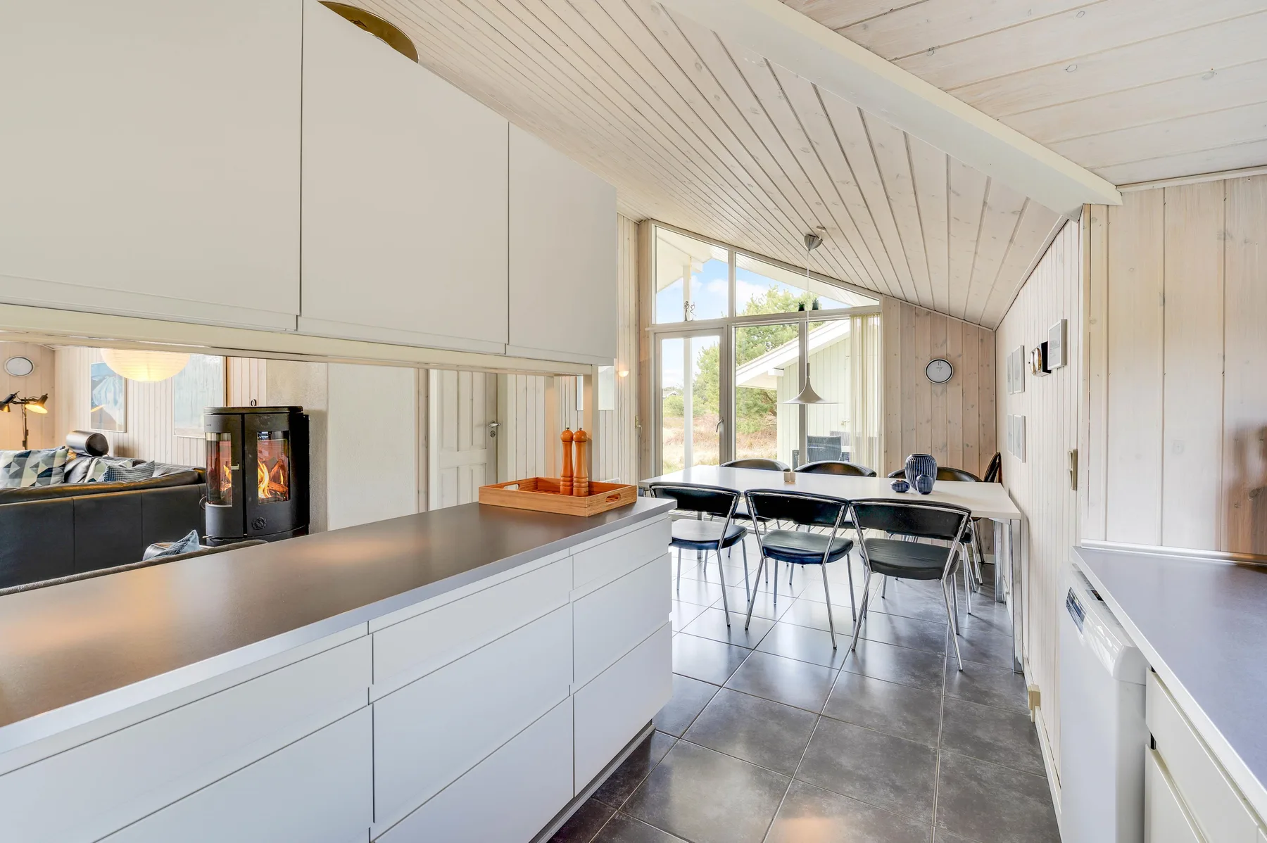 A bright kitchen and dining area with a long counter and large windows.