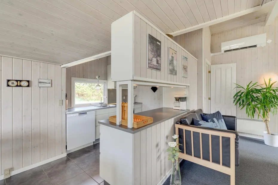 A bright open-plan kitchen and living area with a counter and seating.