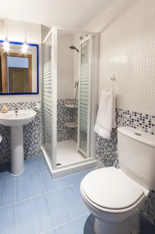 A tiled bathroom with a shower, sink, and toilet.