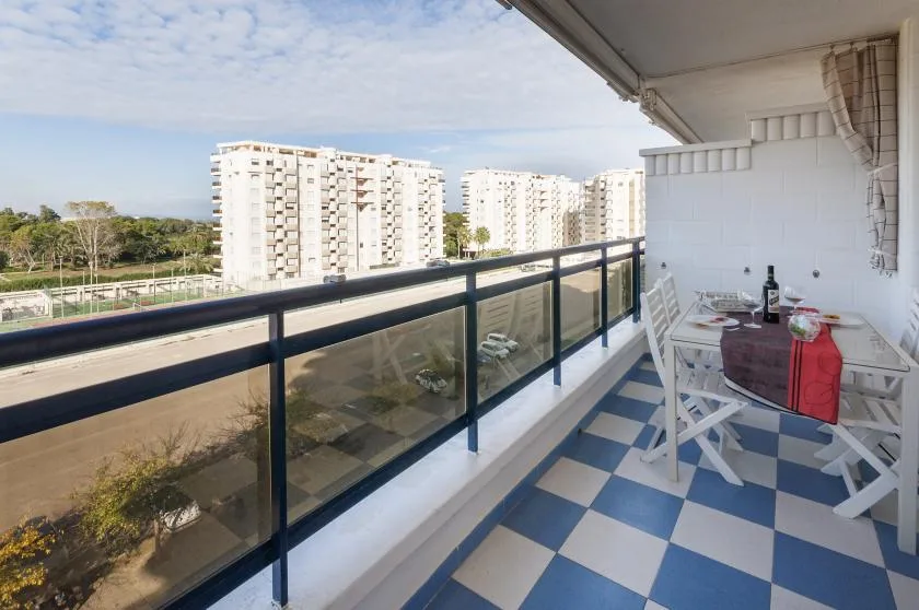 A balcony with a blue-and-white tiled floor and a small dining table.