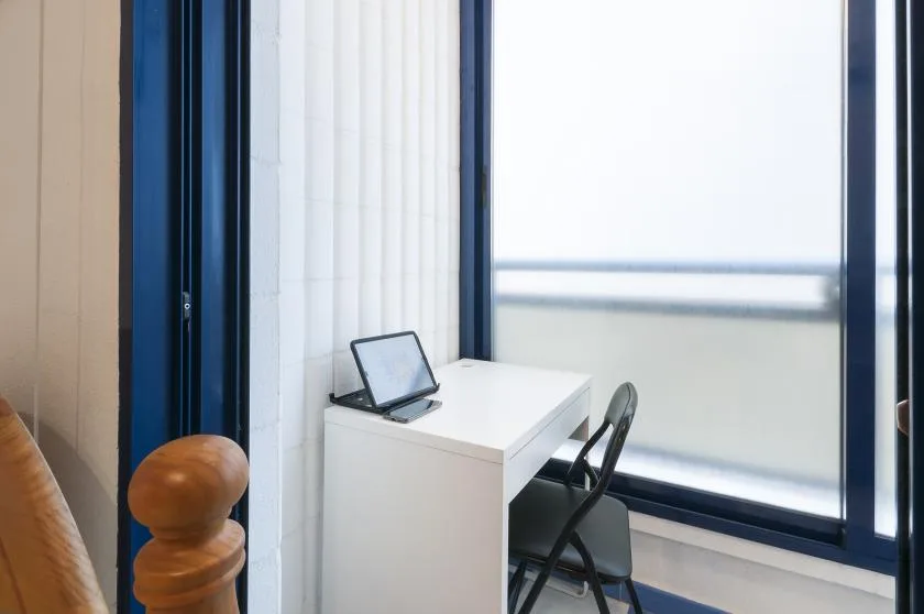 A small workspace with a desk and chair beside a large window.