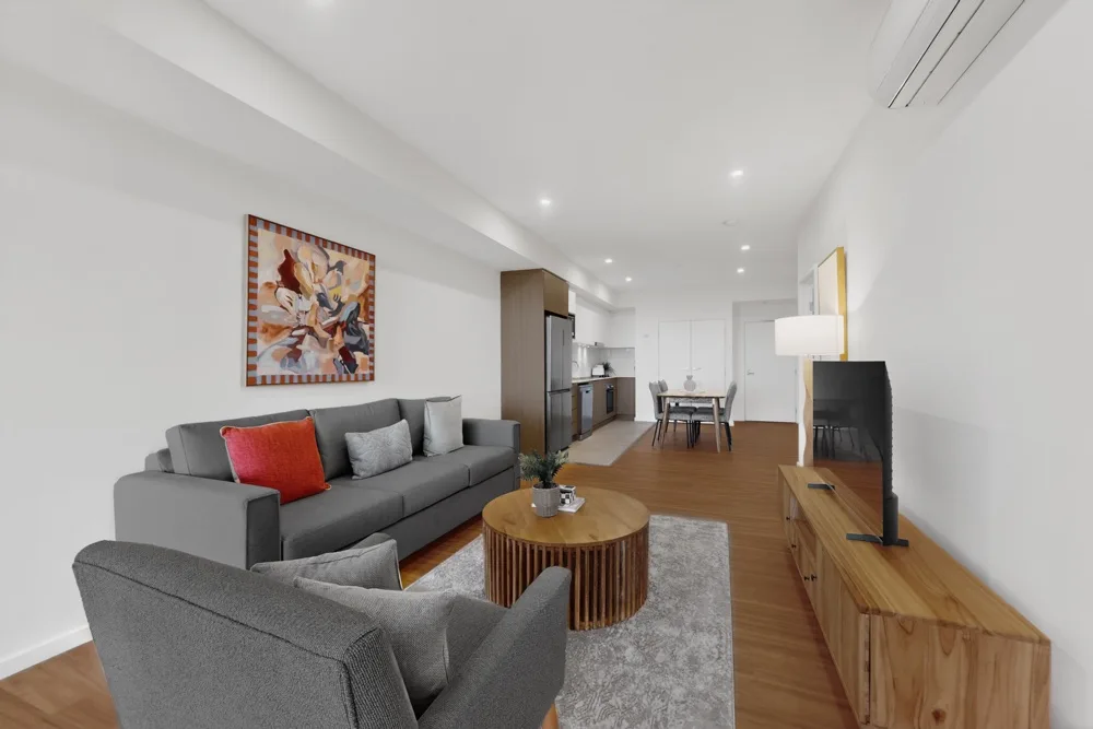 Sala de estar con asientos grises y una mesa de centro.