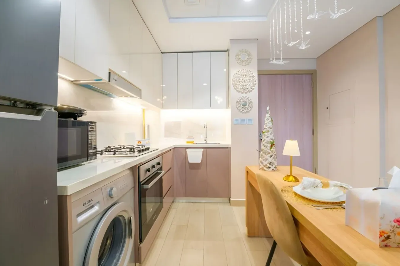 Una cocina luminosa con mesa de comedor y electrodomésticos integrados.