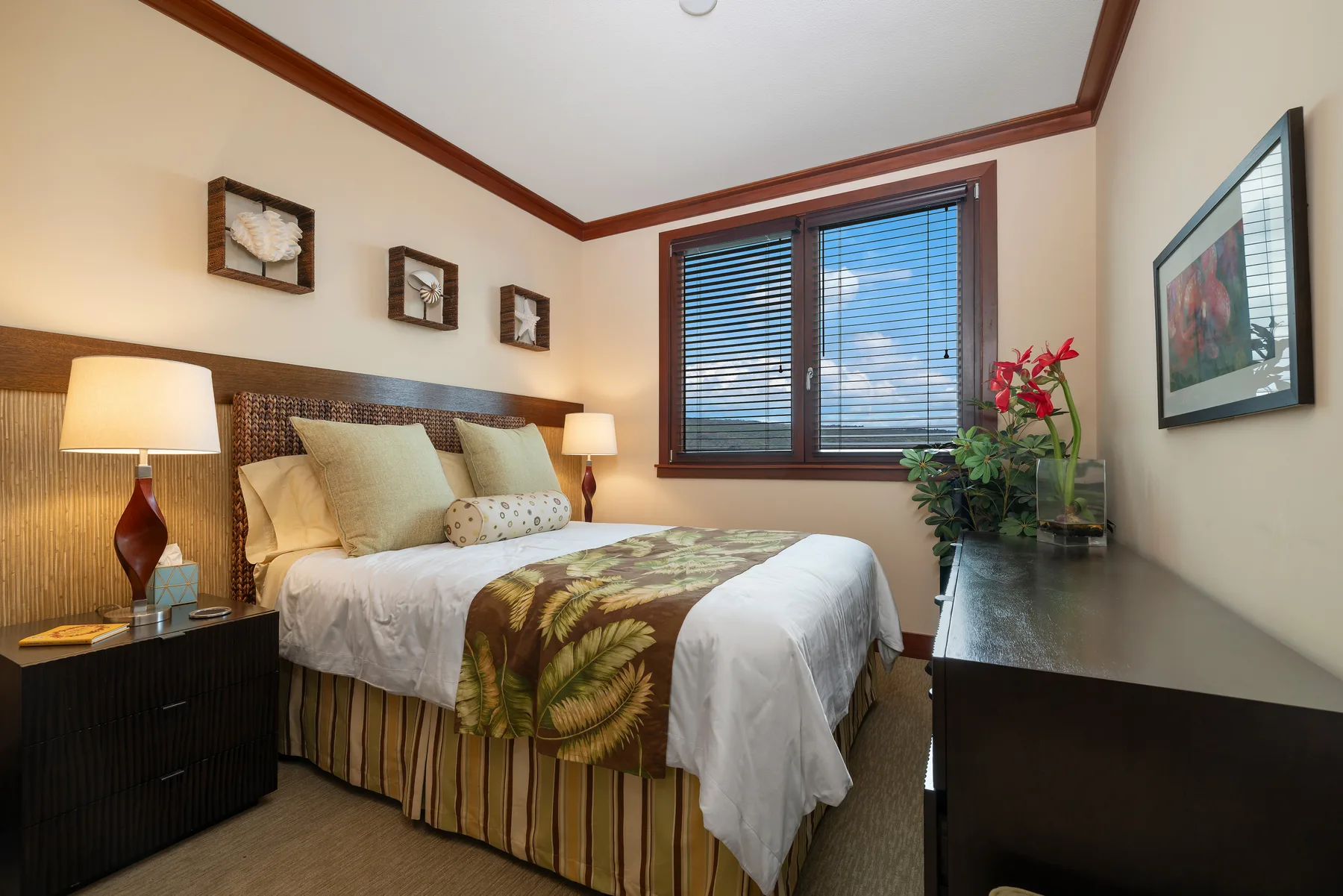 Un dormitorio con una cama bien arreglada y una ventana con persianas.