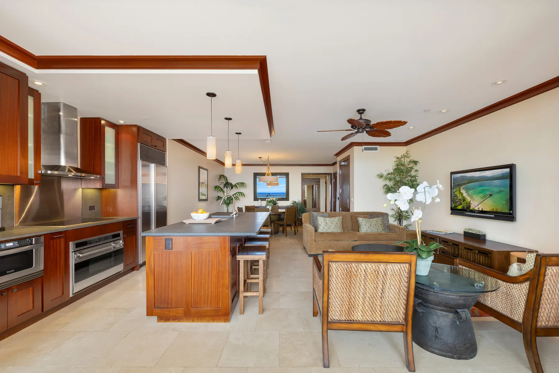 Una cocina y sala de estar de planta abierta con una isla central y asientos.