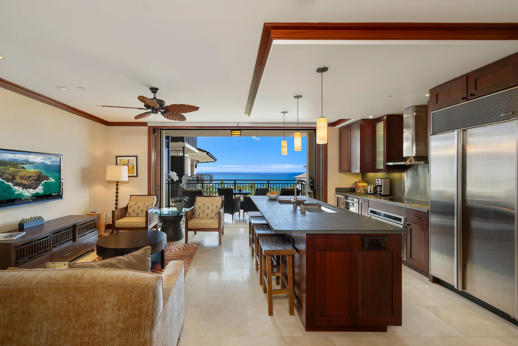 Sala de estar y cocina de concepto abierto, con una isla y vistas al mar.