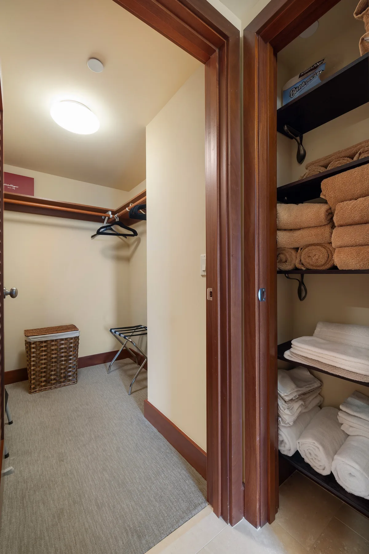Un vestidor con espacio para colgar ropa y estantes con toallas dobladas.