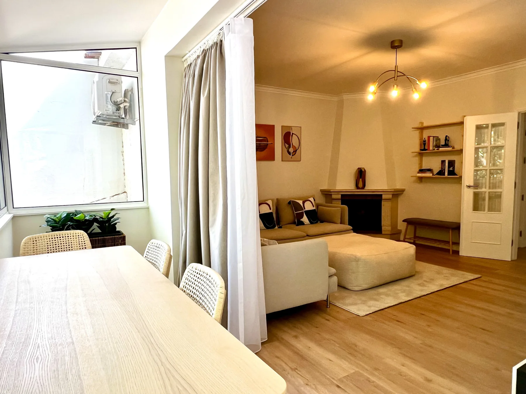 Una luminosa sala de estar y comedor con asientos, una mesa de centro y ventanas grandes.