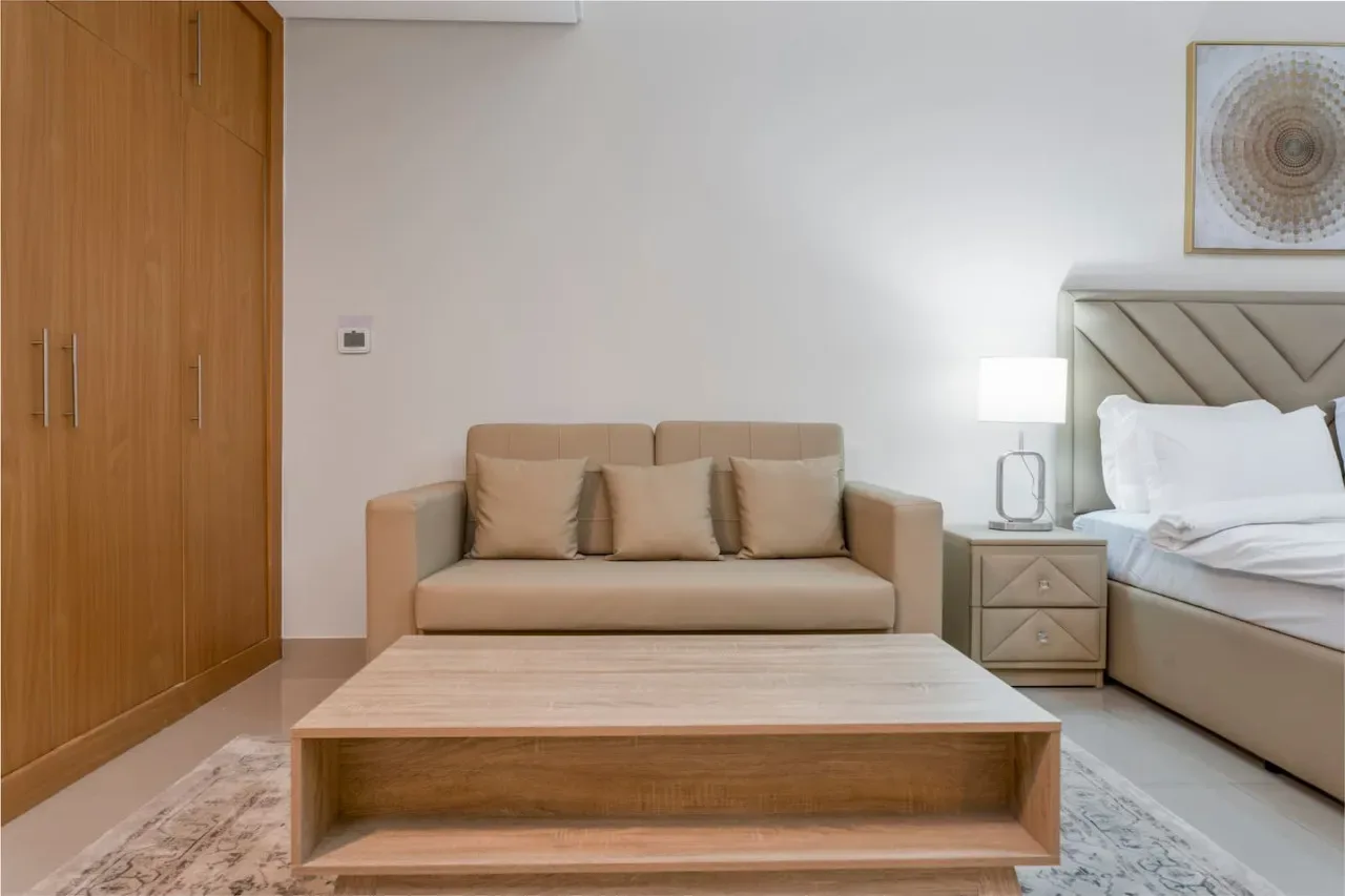 A bedroom with a bed, seating area, and low wooden coffee table.