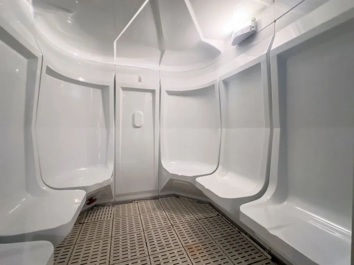 A bright shower room with molded seating and a patterned floor.