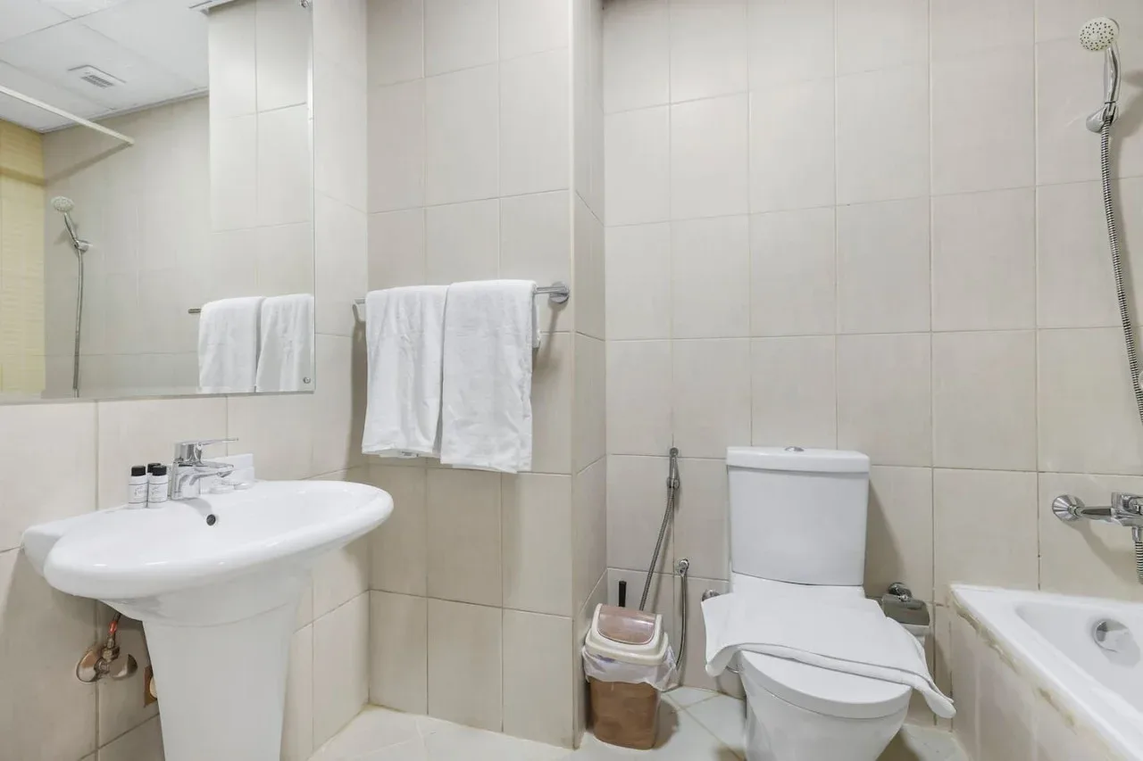A tiled bathroom with a sink, toilet, and bathtub.