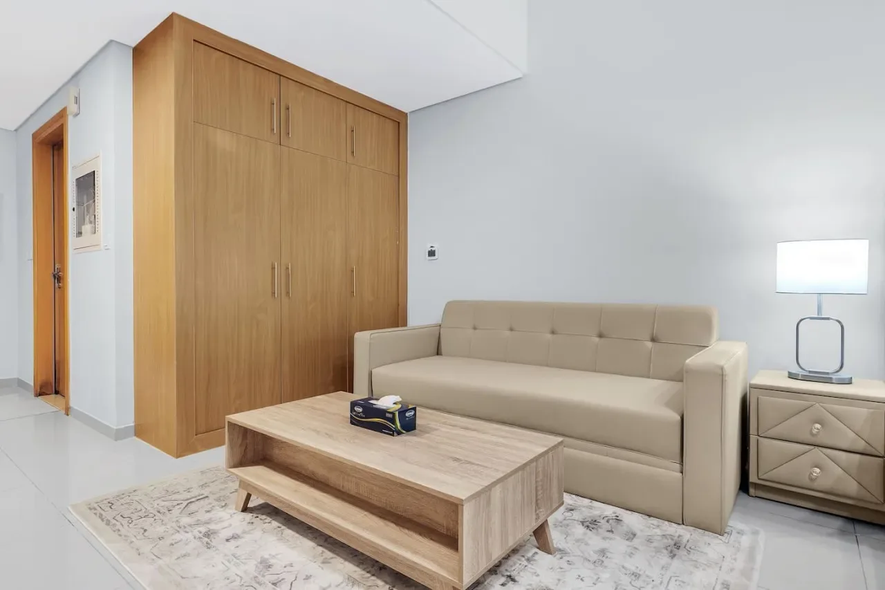 A living room with a beige sofa, wooden coffee table, and built-in cabinets.