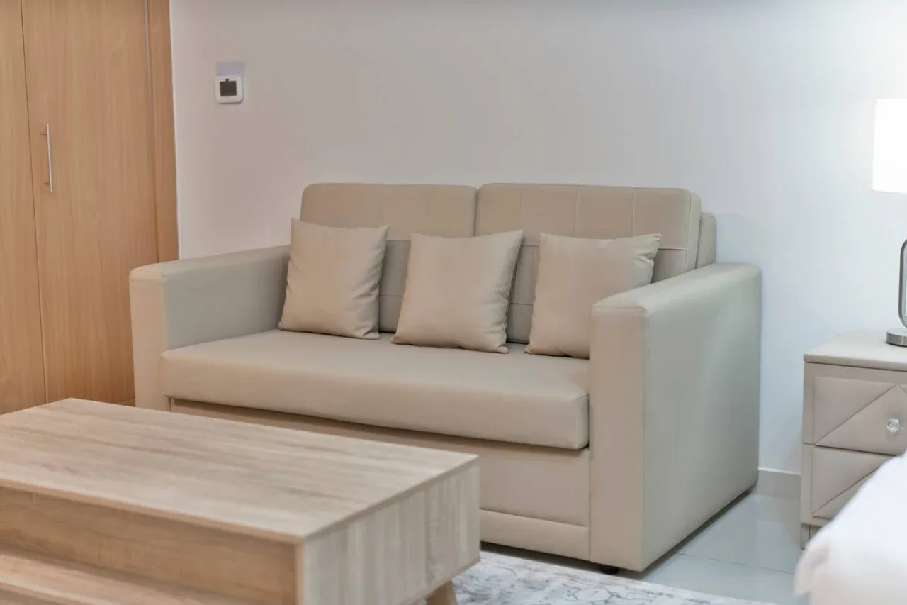 A living room with a beige sofa and a light wood coffee table.