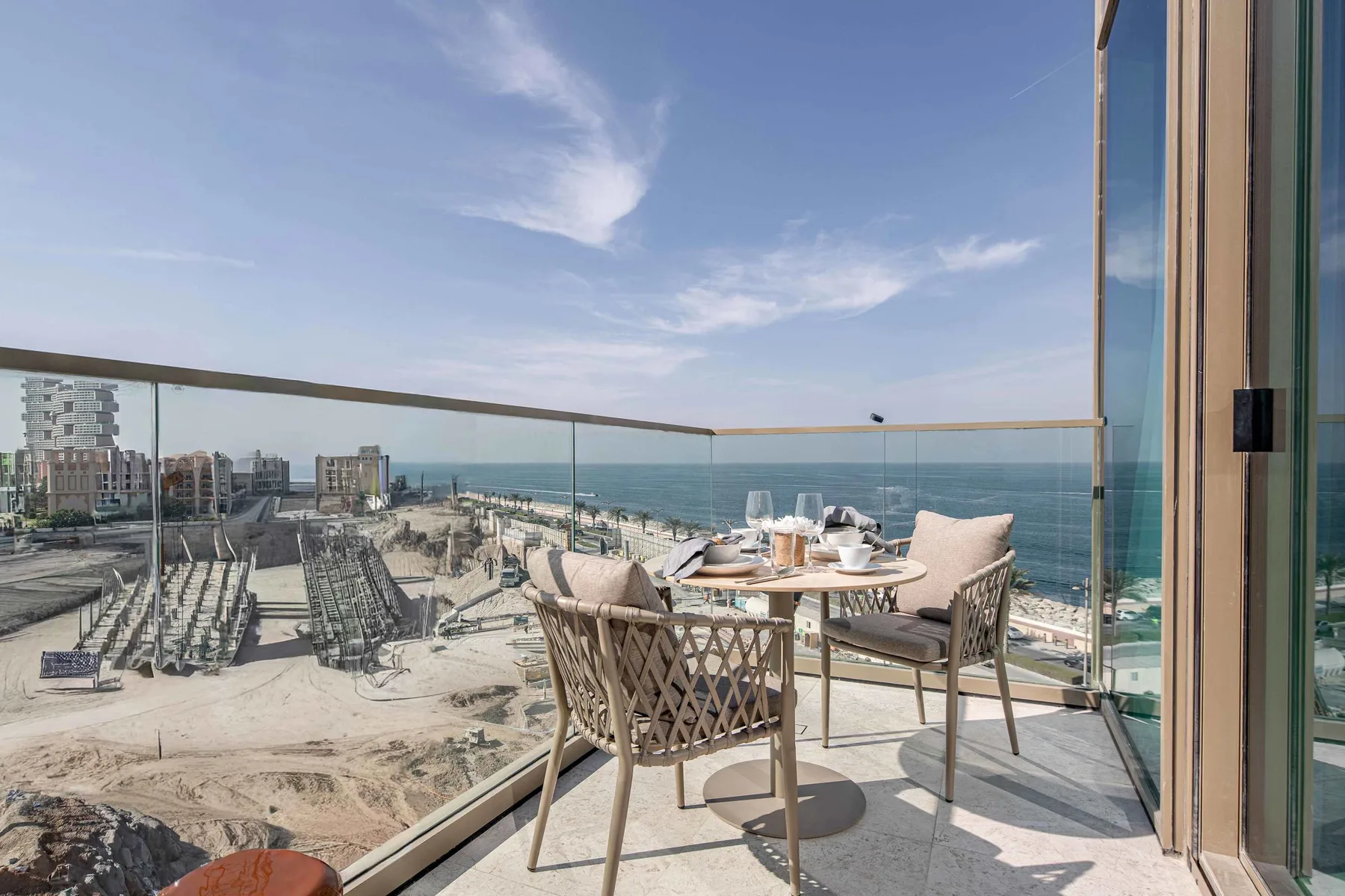 Una zona de comedor en el balcón da a la playa y al mar.