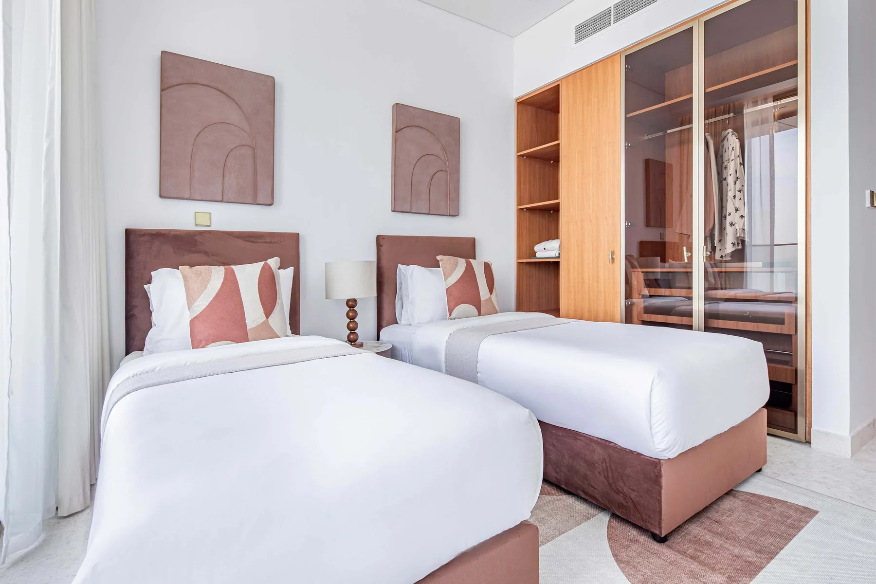 Un dormitorio con dos camas y un armario de madera.