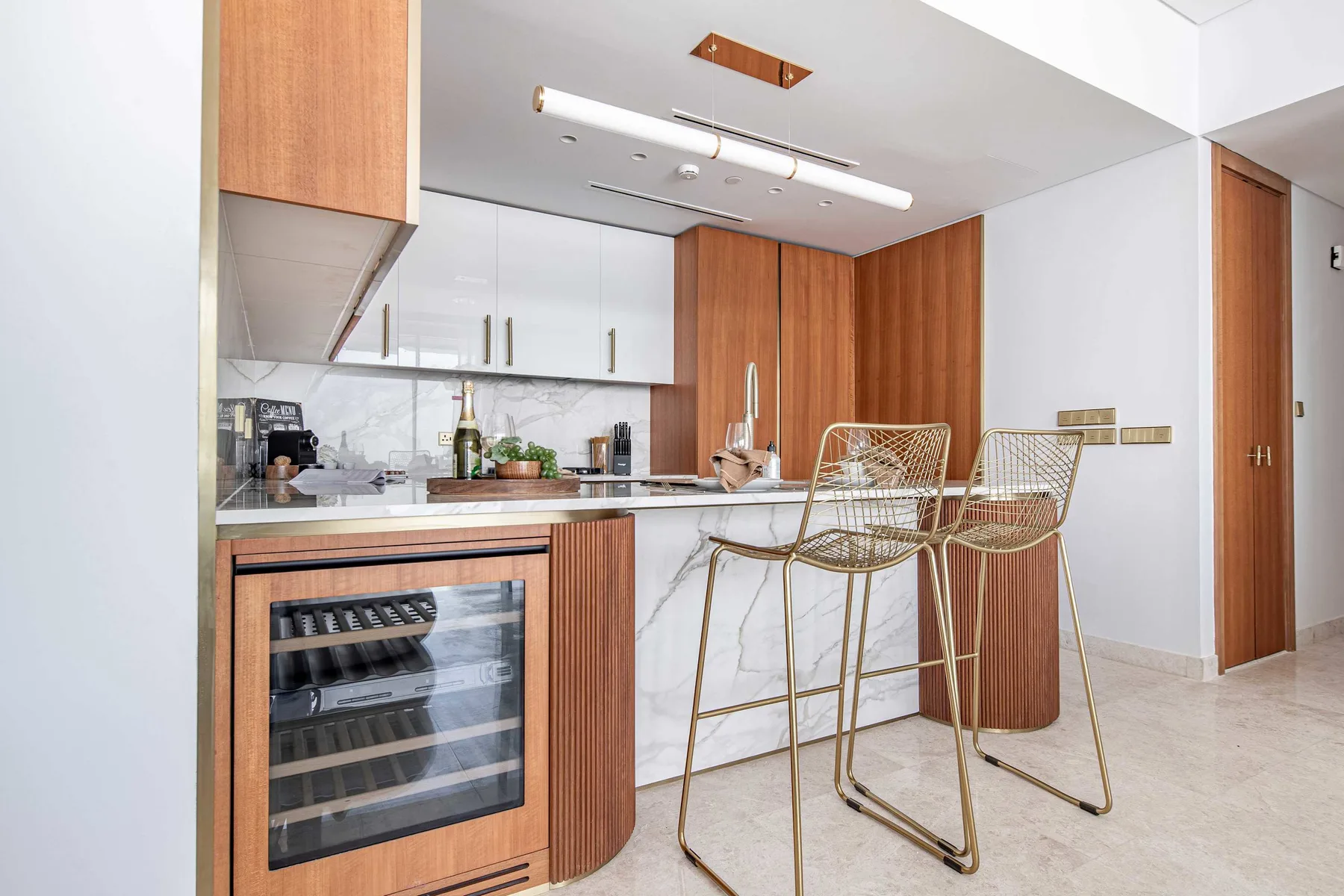 Una cocina moderna con una barra y taburetes metálicos.