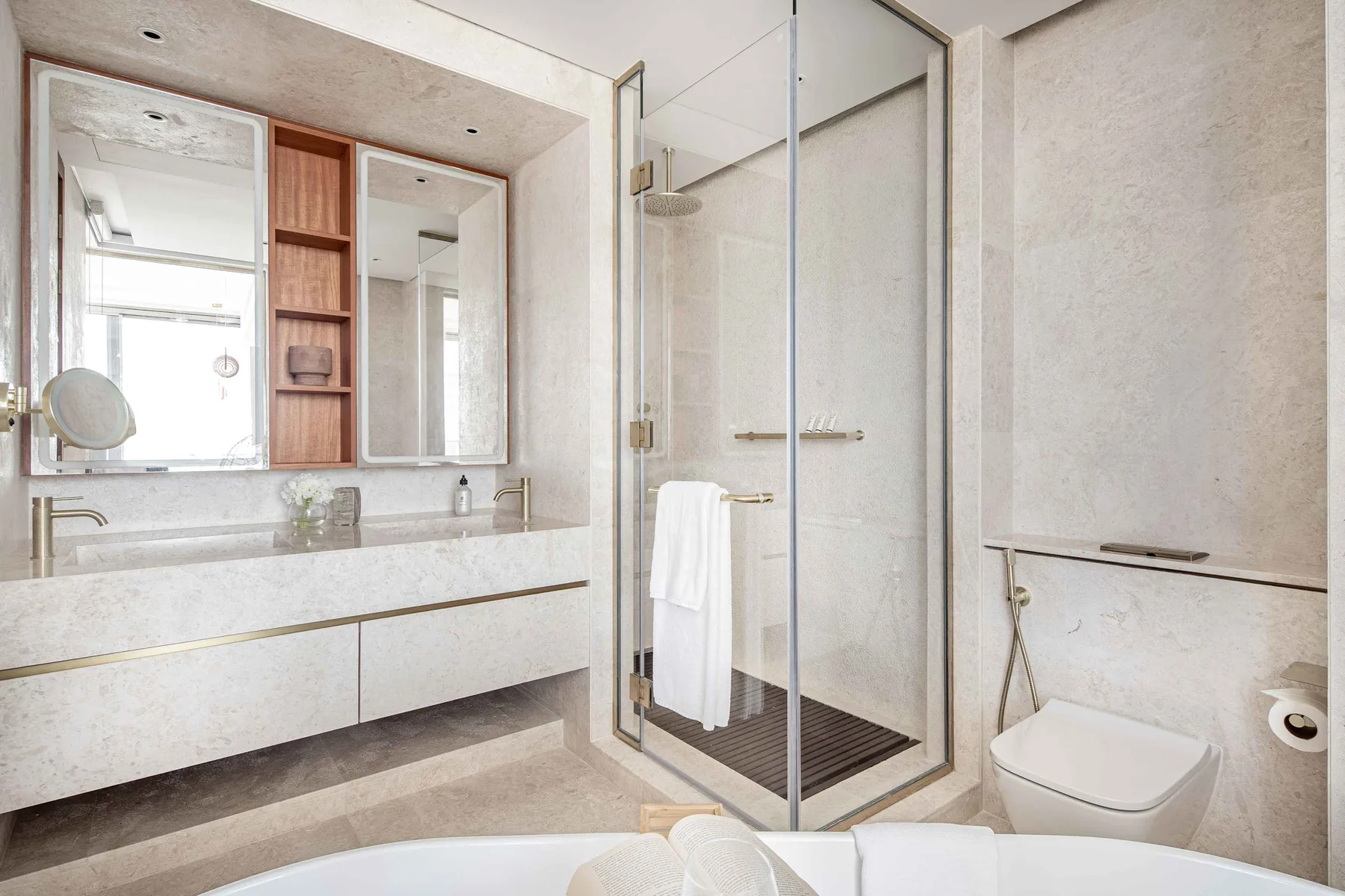 Un baño luminoso con tocador de doble lavabo, ducha de vidrio e inodoro.