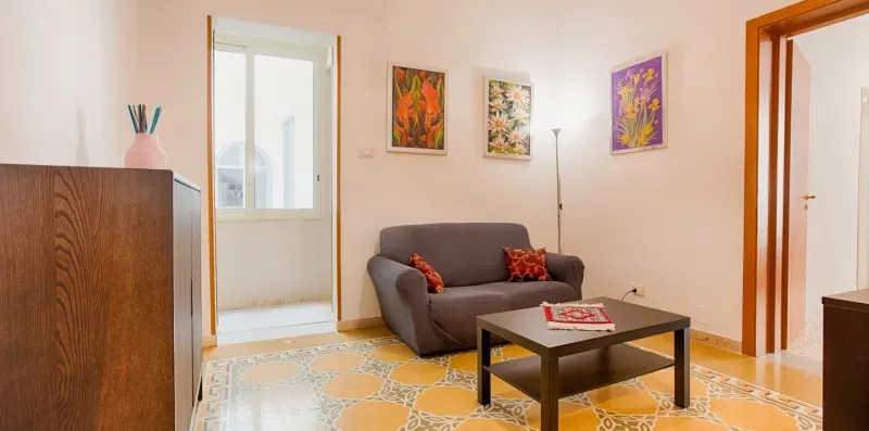 A living room with seating, a coffee table, and colorful artwork on the walls.