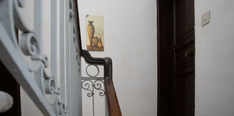 A stairwell with an ornate railing and a framed picture on the wall.