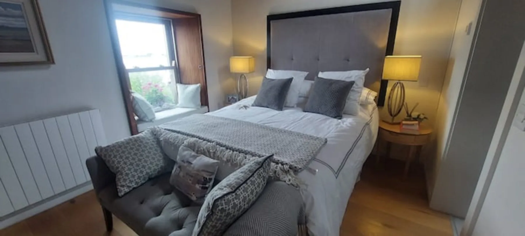 Un dormitorio con una cama grande y una ventana al lado.