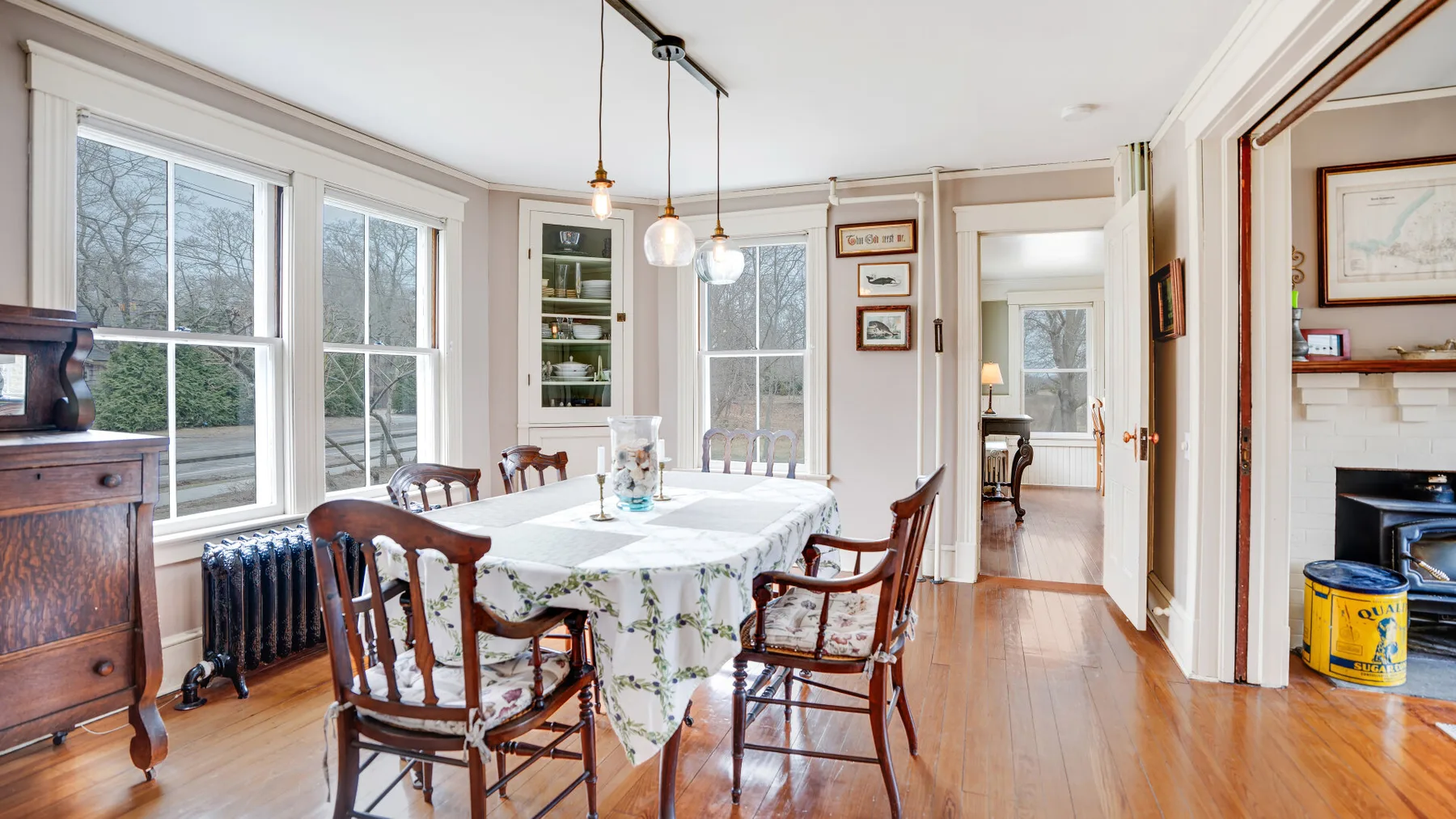 A bright dining room with a table set by large windows.