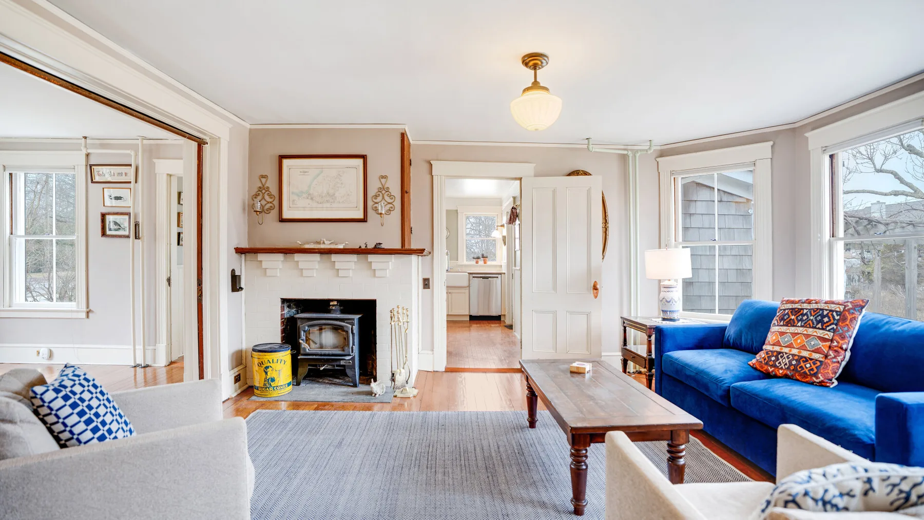 Una sala luminosa con asientos azules, una chimenea y una mesa de centro de madera.