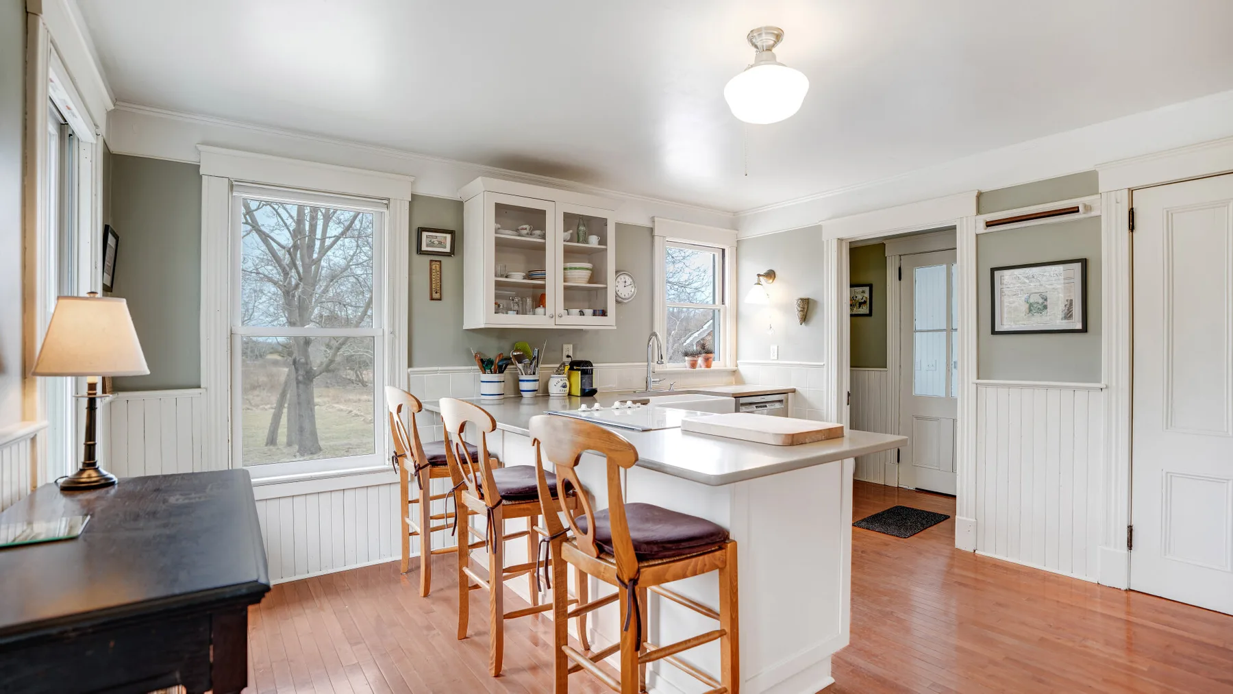 Una cocina luminosa con una isla central y asientos de madera.