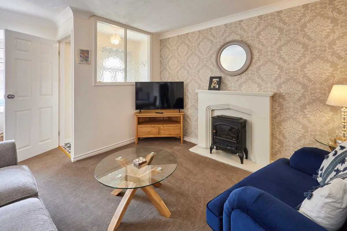 A living room with seating, a television, and a fireplace.