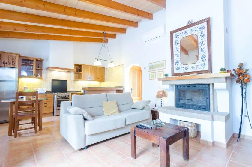 Una sala de estar y cocina abiertas, con asientos junto a una chimenea.