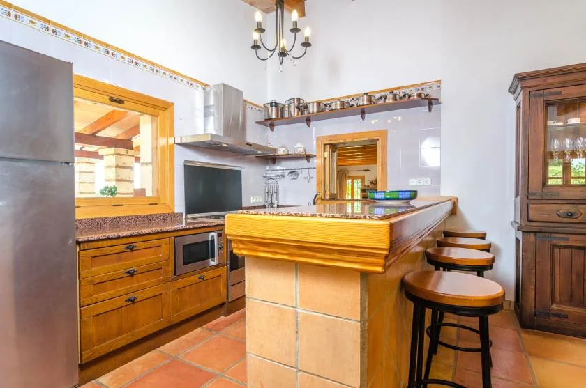 Una cocina rústica con una isla de azulejos y gabinetes de madera.