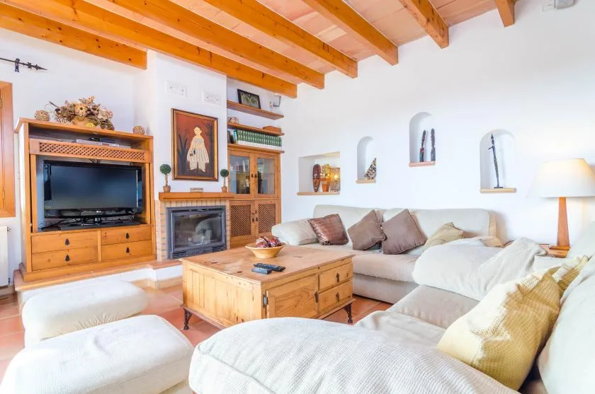 Una sala luminosa con una zona de asientos y una mesa de centro de madera.