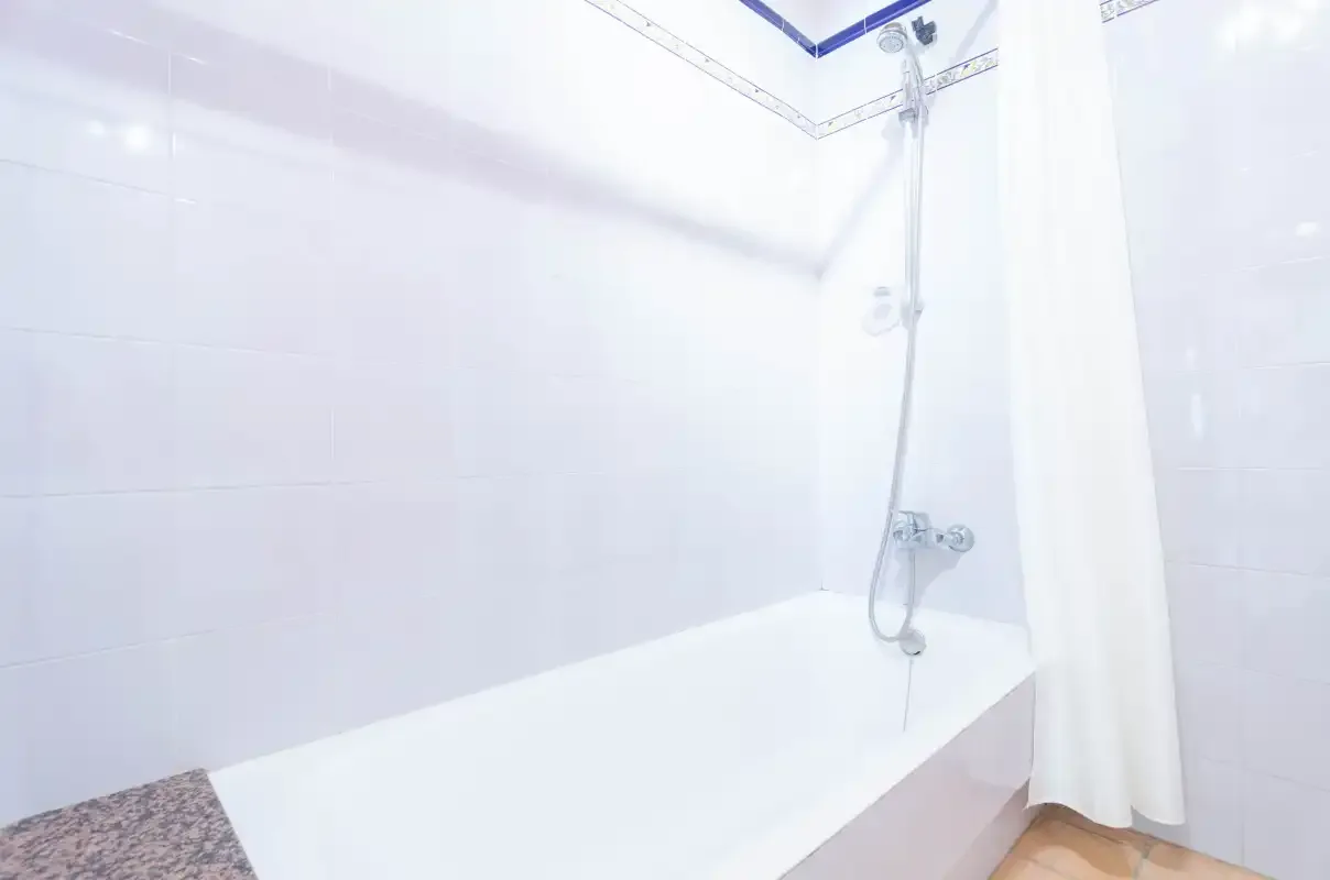 Un baño alicatado con bañera y ducha.