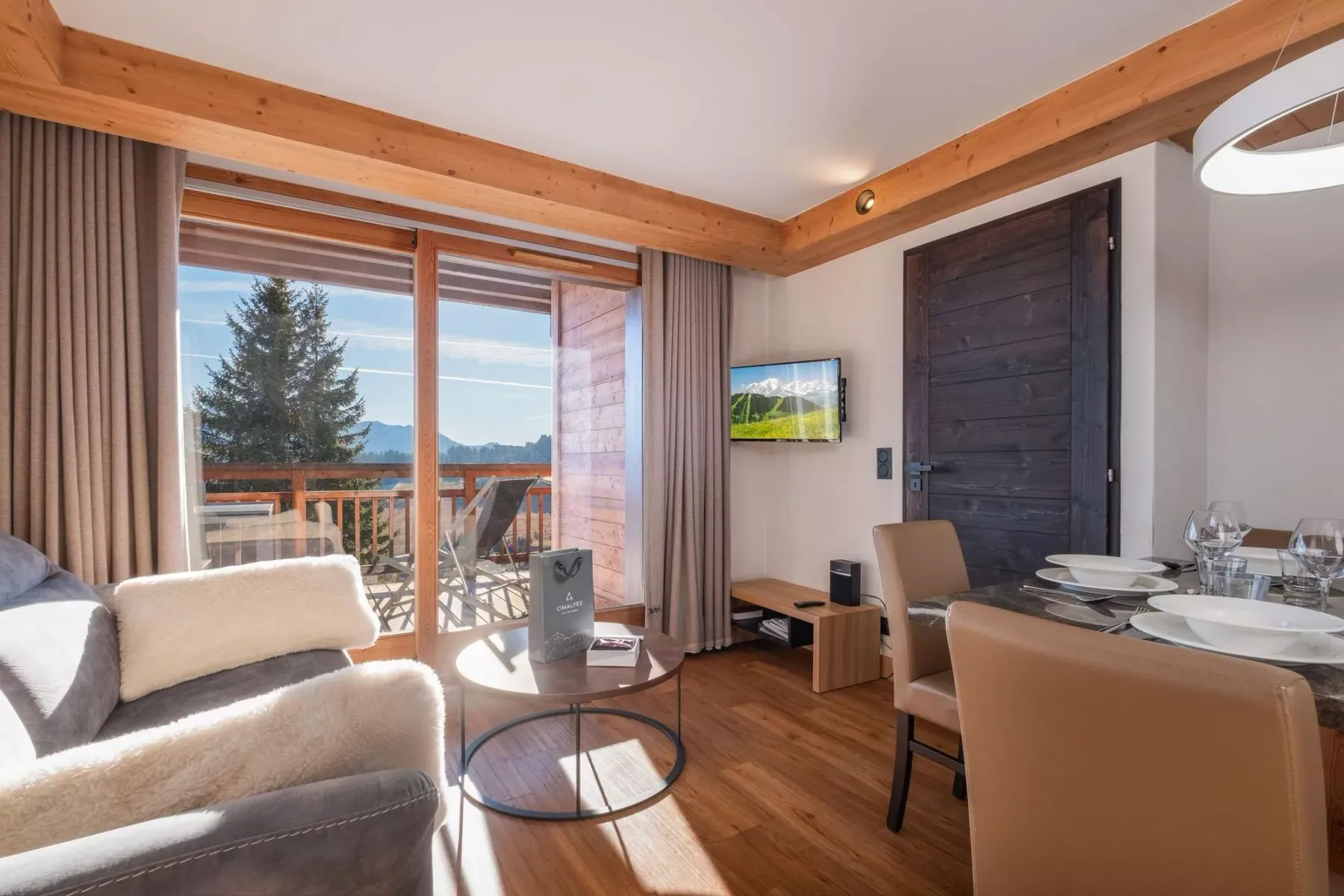 A living and dining area with a sofa, dining table, and large windows.
