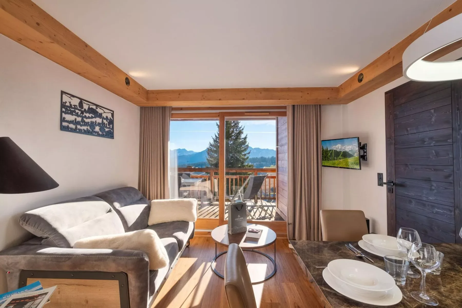 Living room with seating and a dining table beside a balcony.