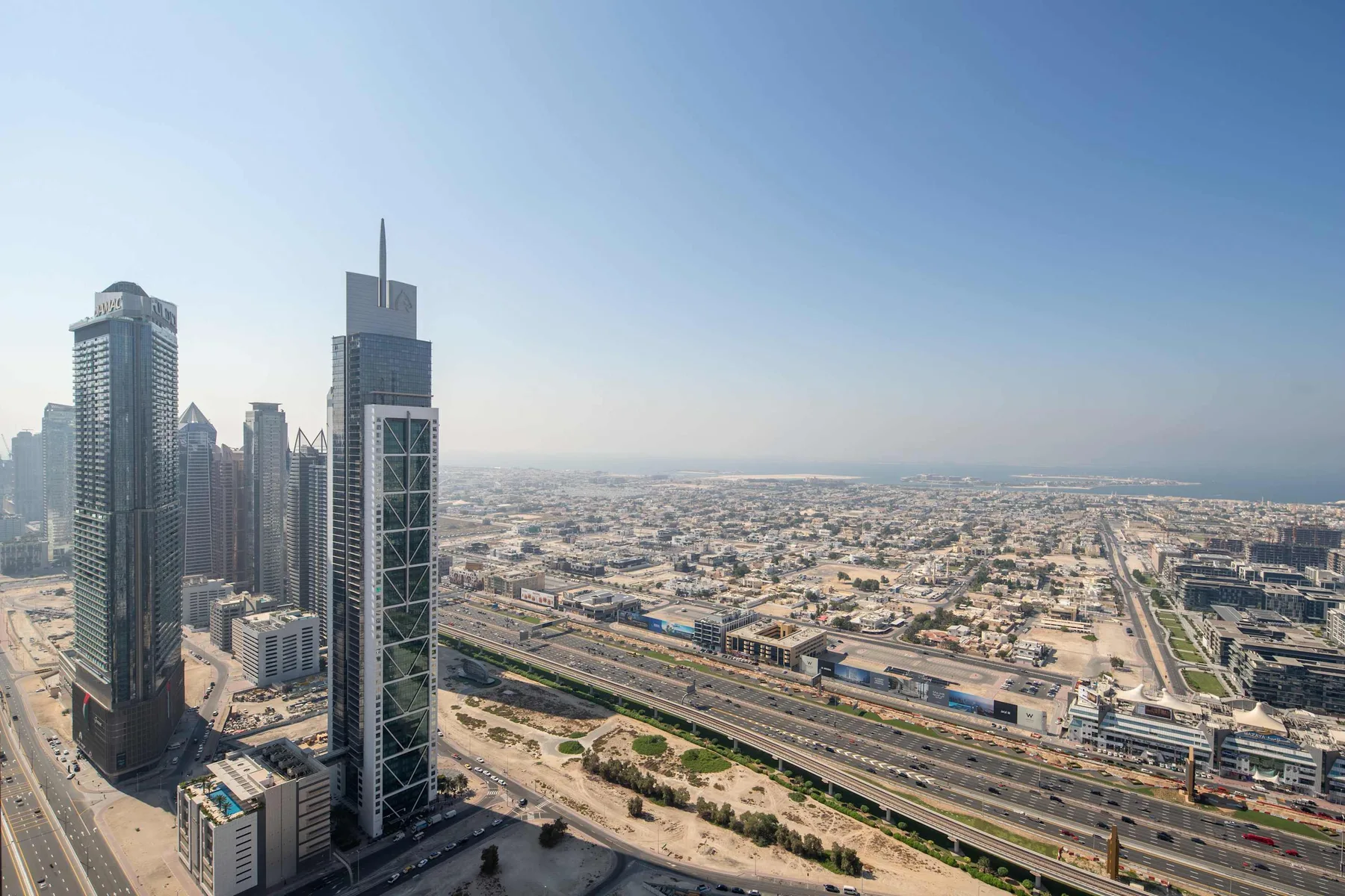 A city skyline overlooks a broad urban landscape and multilane roads.
