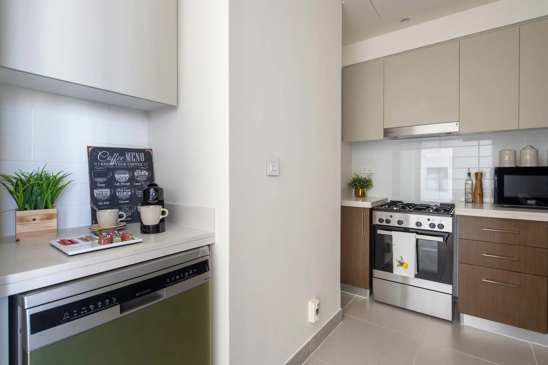 A bright kitchen with a countertop coffee station and a stainless steel range.