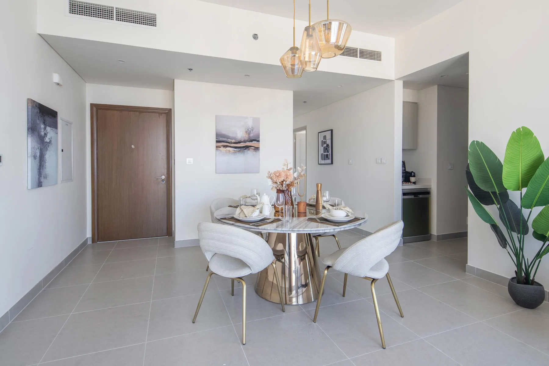 A dining area with a round table set beneath pendant lights.