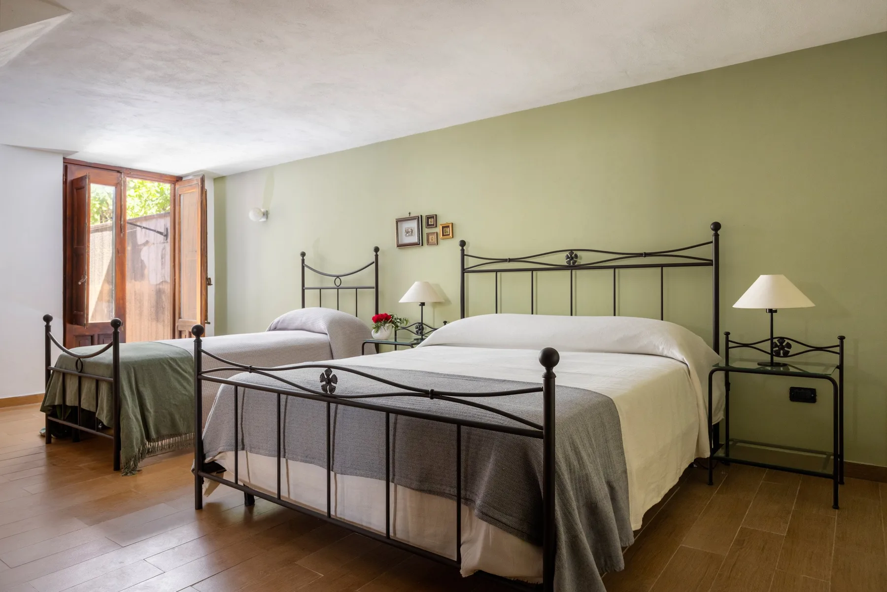 Un dormitorio con dos camas, mesitas de noche y una ventana.